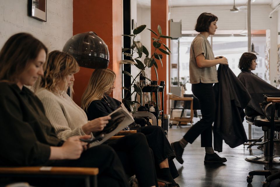 Clients waiting in a busy salon seating area